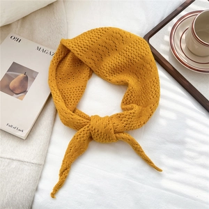 Detail of ginger yellow knitted hollow crochet scarf in a cozy lifestyle setting