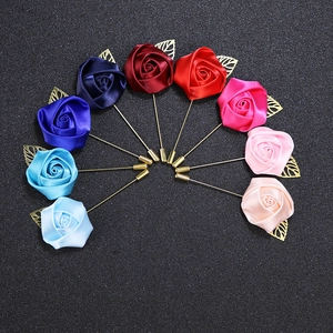 Macro detail of satin rose lapel pins with golden leaves in various vibrant colors