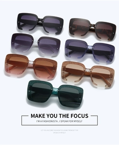 Detailed view of oversized square sunglasses featuring glitter frames and rivet accents