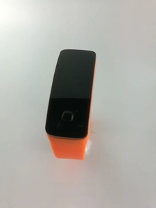 Vue détaillée du bracelet en silicone orange vif et de l'écran tactile LED rectangulaire noir