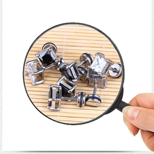 Macro shot of square-cut black and white cubic zirconia studs with four-claw setting