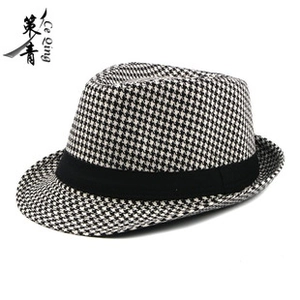 Detailed view of black and white houndstooth pattern and black band on British fedora hat