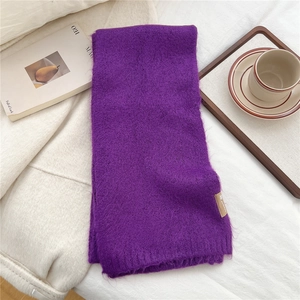 Detailed close-up of a purple knit scarf showing soft mohair texture and fringe edges