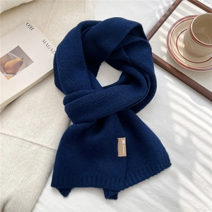Detailed view of dark blue knit scarf texture and premium stitched brand label