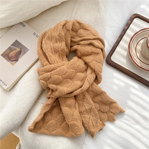 Close-up of caramel knitted scarf featuring thick fish-scale pattern and wavy edge detail