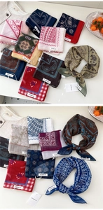 Flat lay of colorful paisley and floral cotton bandanas styled with an apricot shirt