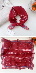 Detail of red paisley cotton linen scarf with plaid border and brand tag detail