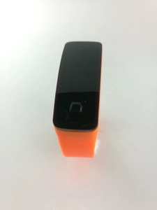 Gros plan d'une montre de sport LED orange avec bracelet en silicone et écran tactile noir