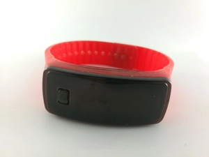 Gros plan sur un bracelet de sport en silicone rouge avec écran tactile LED rectangulaire
