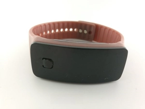 Détail d'une montre numérique LED avec bracelet en silicone rouge foncé et boucle réglable