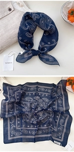 Close-up of navy blue paisley cotton bandana with classic white pattern and brand tag