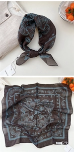 Detailed macro view of dark brown paisley silk scarf with delicate light blue floral pattern