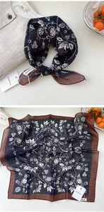 Close-up of navy blue floral cotton scarf with detailed vine patterns and brown borders