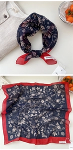 Close-up of vintage floral print scarf with navy blue and red border in soft texture