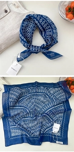 Detailed view of dark blue cotton linen scarf with white leaf prints and brand tag