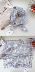 Detail of light blue and brown checkered cotton scarf with textured weave and brand tag