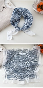 Detail of artistic cotton linen square scarf with blue leaf patterns and textured fabric