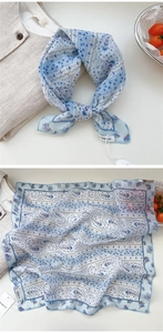 Detailed view of light blue floral scarf with elegant lace patterns and wavy stripe design