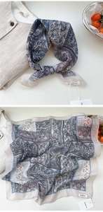 Detail of soft paisley floral cotton linen scarf with elegant blue and tan patterns