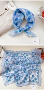 Detail view of lightweight blue ink-dot silk scarf texture and elegant fabric draping