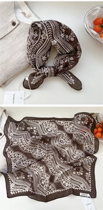 Detail view of brown paisley cotton linen scarf showing soft floral pattern and texture