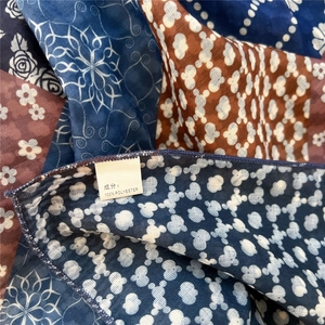 Detailed close-up showing the 100% polyester fabric and paisley patterns on the small scarf