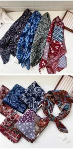 Macro detail of various paisley and floral cotton linen scarves with elegant drape texture