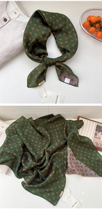 Detail of green silk-like scarf with brown polka dots and 100% polyester fabric label