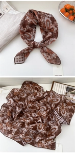 Detail of brown paisley cotton linen scarf showing intricate patterns and edge stitching