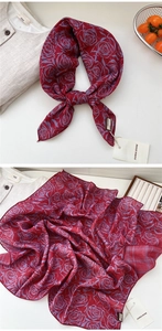 Detail of burgundy linen-cotton scarf featuring blue floral patterns and brand labels