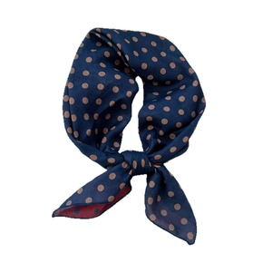 Navy blue cotton linen scarf with brown polka dots tied in a decorative neck knot