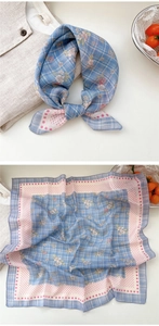 Detail of floral linen square scarf with blue checkered patterns and pink polka dot border