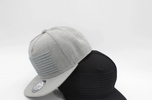 Détail de casquettes snapback grises et noires avec broderie du drapeau américain