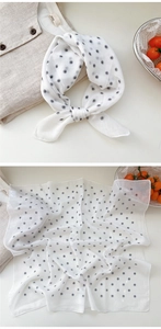 Detailed close-up of white polka dot linen scarf with delicate rolled edge finish