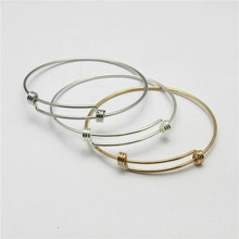 Macro view of adjustable open-loop metal bracelets in polished silver and gold finishes