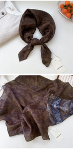 Détail d'un foulard marron vintage à motifs paisley avec étiquette de marque élégante