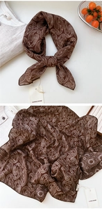 Détail d'un foulard en soie marron à motif cachemire avec étiquette de marque