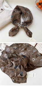 Détail d'un foulard en soie marron à carreaux avec papillons bleus et fleurs