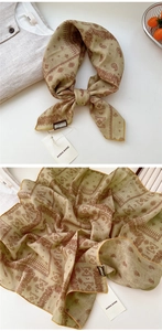 Détail d'un foulard paisley vintage avec bordure dorée et texture soyeuse