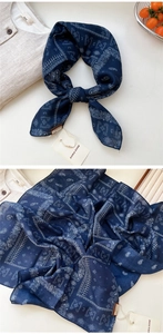 Détail d'un foulard en soie bleu marine à motif paisley vintage et texture douce