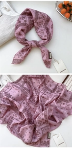 Détail macro d'un foulard rose en coton lin avec motif paisley vintage et étiquette de marque