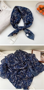 Gros plan du foulard cachemire bleu foncé aux motifs floraux et texture de tissu élégant