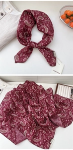 Détail macro du foulard en soie bordeaux avec motif cachemire et finition roulottée fine