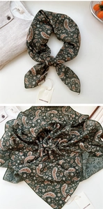 Détail d'un foulard en soie à imprimé cachemire avec des bords roulés fins en vert