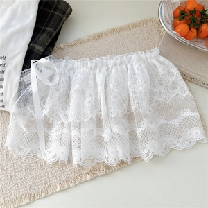Détail de la jupe en dentelle florale blanche multicouche avec cordon de serrage en satin blanc
