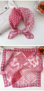 Close-up of pink floral linen scarf with intricate patchwork patterns and grid border