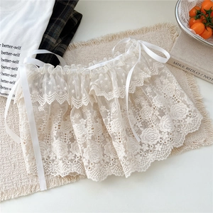 Détail d'une jupe en dentelle florale blanche avec rubans délicats et bords festonnés