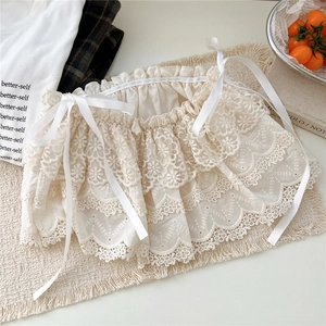 Détail d'une jupe superposée en dentelle florale blanche avec broderie et liens en satin