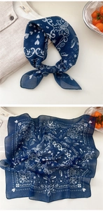 Detail of dark blue linen scarf with white heart and coffee motifs tied as a bow