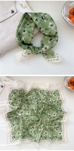 Detail of green floral linen scarf showing daisy print and geometric border texture